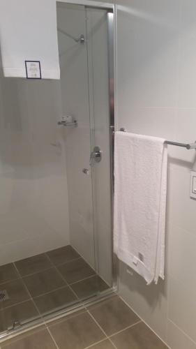 a shower with a glass door and white towels at Camden Valley Terrace 4 in Cawdor