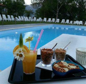 una bandeja de comida y bebida en una mesa junto a la piscina en OSTELLO MIRABEAU, en Bellagio