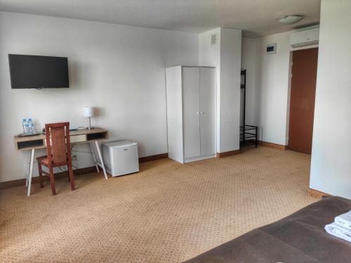 an empty room with a desk and a tv on the wall at Hotel Logos in Warsaw