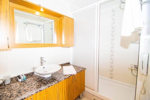 a bathroom with a sink and a shower at Mesken Inn Hotel in Göcek