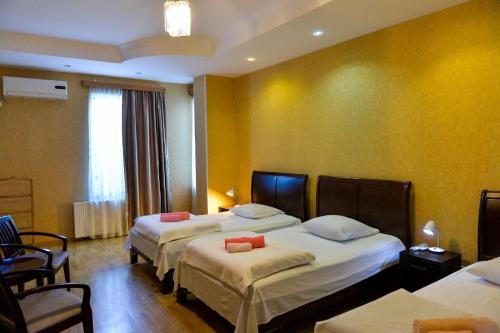 ein Hotelzimmer mit 2 Betten und einem Fenster in der Unterkunft Argopalace in Kutaissi