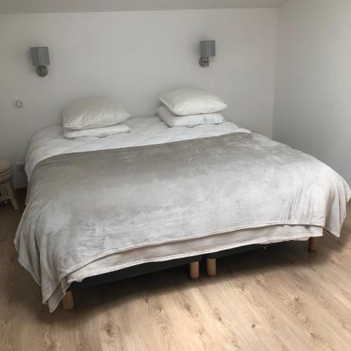 a large bed with white sheets and pillows on it at Manoir de Champvert in Les Vans