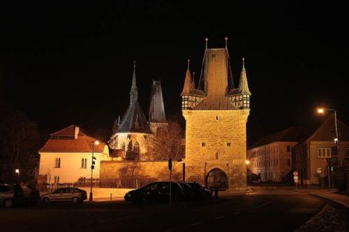 a large building with a clock tower at night at Rozmaryn Rooms & Apartments in Rakovník