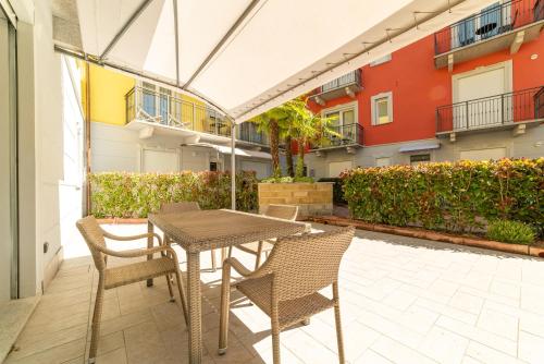a patio with a table and chairs and a building at Yachting Residence in Lavena Ponte Tresa