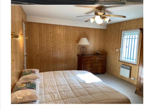 ein Schlafzimmer mit einem großen Bett und einem Deckenventilator in der Unterkunft Une Vue Exceptionnelle in La Trinité-sur-Mer