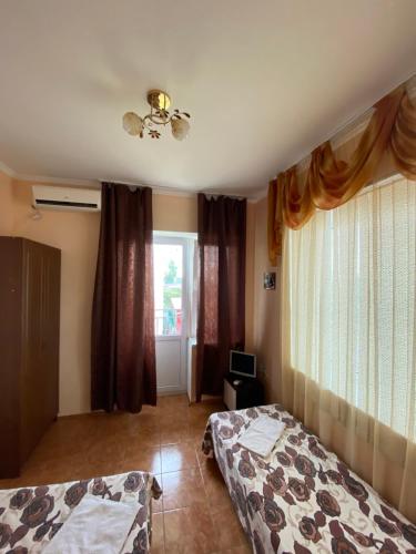 a bedroom with two beds and a window at Levyi Bereg Guest House in Loo