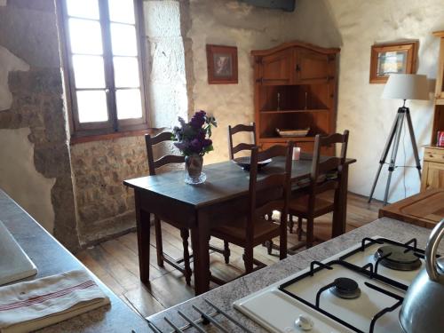 une cuisine avec une table et une cuisinière ainsi qu'une salle à manger dans l'établissement Ambeyrac gîte Cap Del Mas, à Ambeyrac