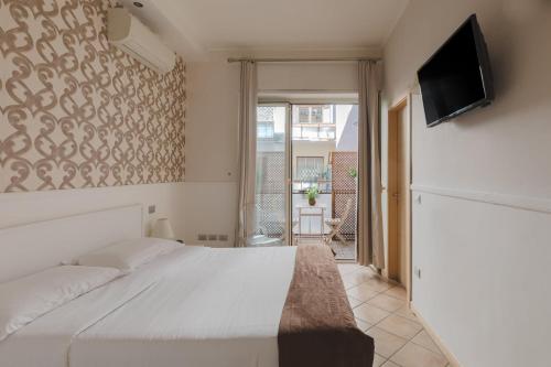 a bedroom with a white bed and a flat screen tv at Residenza Il Giglio in Rome