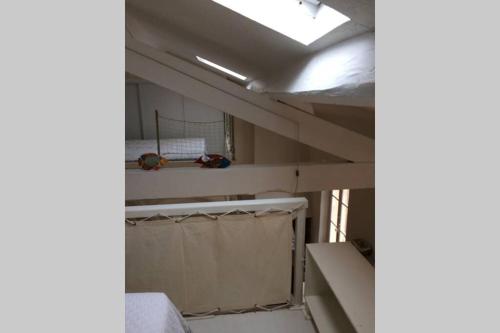 Cette chambre comprend des lits superposés et un plafond. dans l'établissement Appartement à 100 m du village de porquerolles, à Porquerolles
