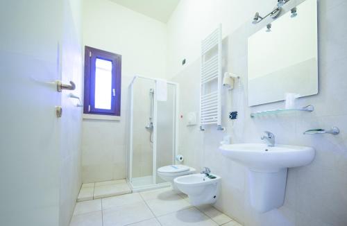 a white bathroom with a sink and a toilet at Delle Rose, Hotel & Restaurant in Torre Vado