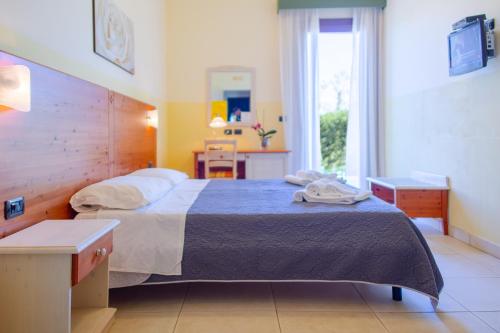 a bedroom with a bed and a table and a window at Delle Rose, Hotel & Horse Riding in Torre Vado