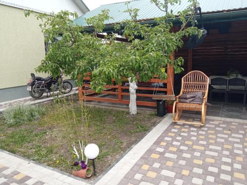 a patio with a chair and a tree at Садиба Герасімових in Kamianets-Podilskyi