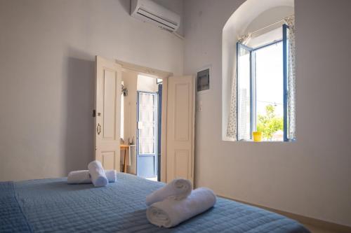 a bedroom with a blue bed with towels on it at Anastasia Traditional House in Lartos