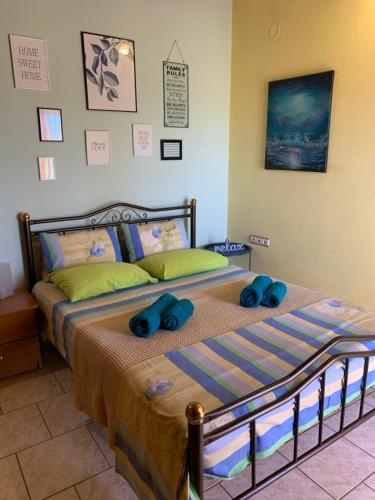 a bedroom with a bed with two blue pillows on it at Aquarella Apartment in Chrysoupolis