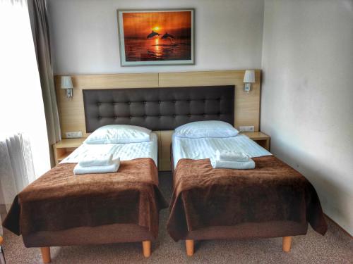a bedroom with two beds and a picture on the wall at Hotel Logos in Warsaw