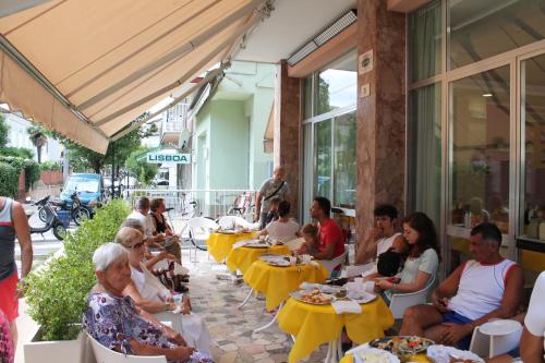 een groep mensen aan tafel in een restaurant bij Hotel Madrid in Cattolica