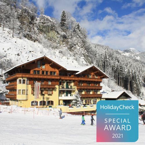 a chalet on a ski slope in the snow at Hotel Kristall in Grossarl