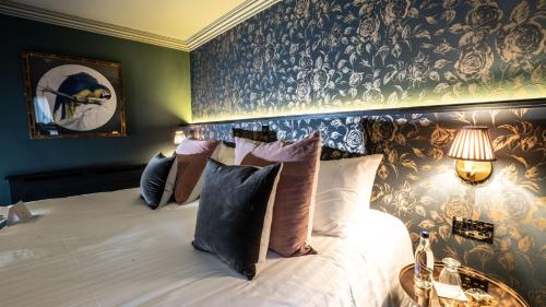 a hotel room with a bed, lamps and a painting on the wall at House Belfast Hotel in Belfast