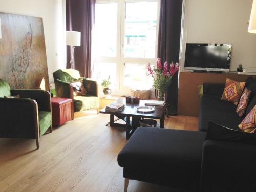 - un salon avec des canapés, une table et une télévision dans l'établissement La Petite Maison, à Marseille