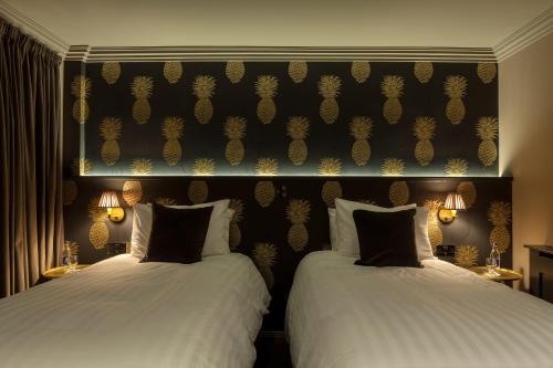 two beds sitting next to each other in a room at House Belfast Hotel in Belfast