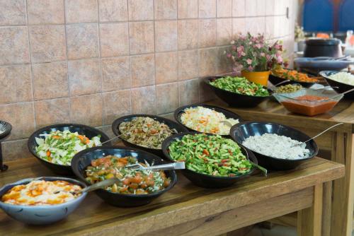 un buffet con platos de diferentes tipos de comida en HI - Shlomi Hostel en Shlomi