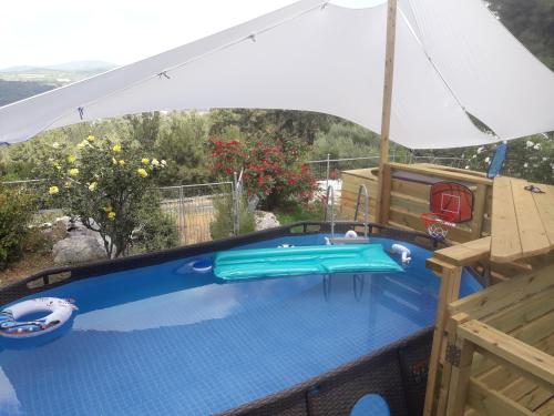 a swimming pool with an umbrella on top of a house at Oren's place - perfect for families & friend's in Kefar Weradim