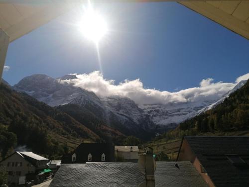 a view of a mountain range with the sun in the sky at Chambres d'hôtes L'Astazou in Gavarnie