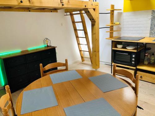 - une table en bois dans une cuisine avec une échelle dans l'établissement charmant T1, au Grau-dʼAgde