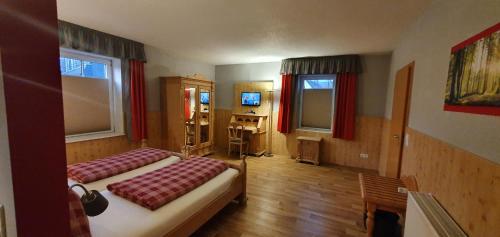 two beds in a room with red curtains at Hotel Bigger Hof - Wirtshaus Platzhirsch am Jahnplatz in Olsberg