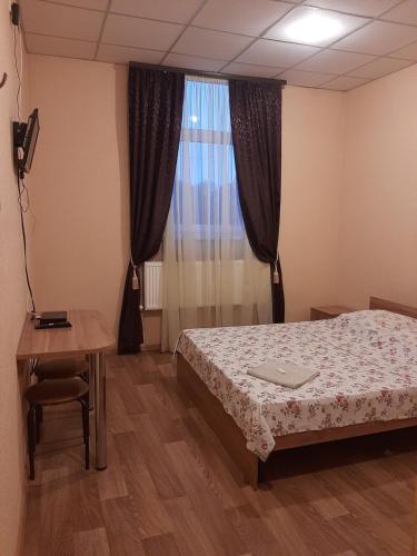 a bedroom with a bed and a table and a window at Прайд Кривой Рог in Kryvyi Rih