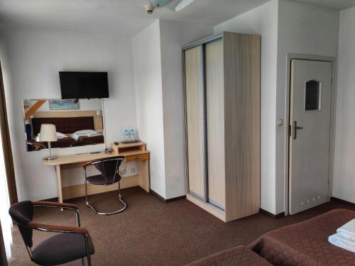 a hotel room with a bedroom with a desk and a bed at Hotel Logos in Warsaw