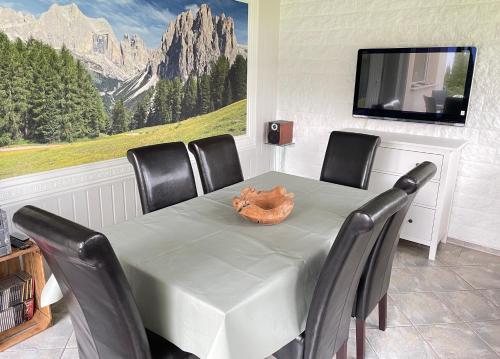 a dining room with a table with chairs and a television at Ferienhaus Kurt in Elbingerode