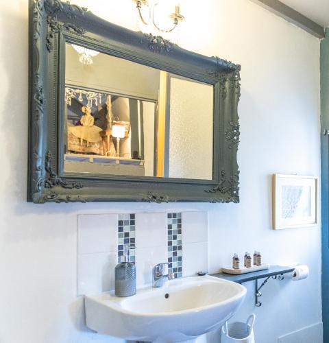 une salle de bain avec un lavabo et un miroir dans l'établissement La Bastide de Canaules, à Canaules-et-Argentières