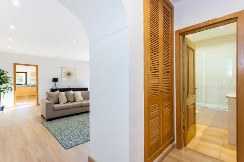 sala de estar con sofá y puerta en Seaview apartment - Estrela da Luz****, en Luz