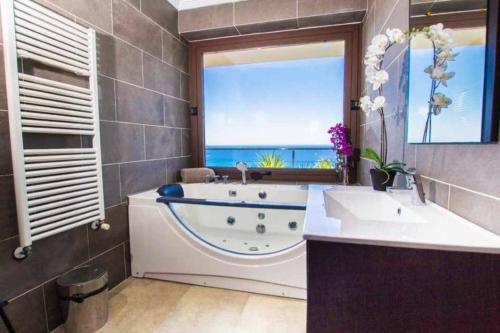 bagno con vasca, lavandino e finestra di Via del Cigne a Capdepera