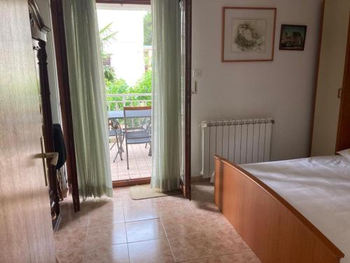 sypialnia z łóżkiem i drzwiami prowadzącymi na balkon w obiekcie IJA w Krku