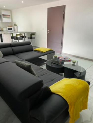 a living room with a couch and a yellow blanket at L'escapade des randonneurs in Lautenbach