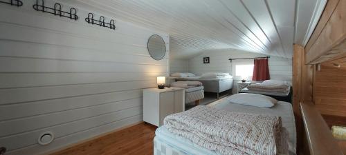 a bedroom with two beds in a room with a ceiling at Hideaway Cottage in Ivalo