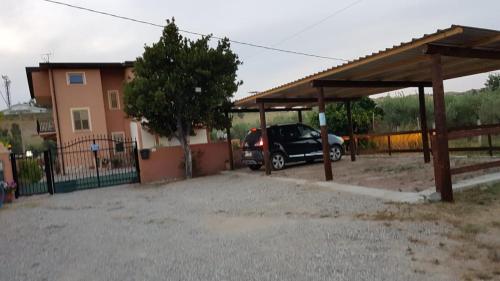 a car parked under a shed in a driveway at IL FEUDO in Sellia Marina