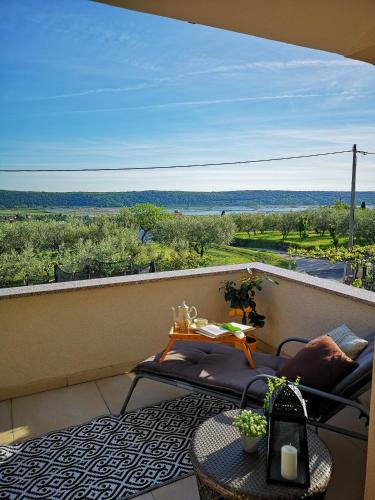a balcony with a table and chairs and a view of the ocean at Apartma Isabella in Sečovlje