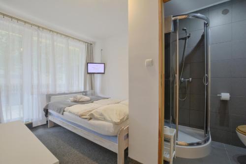 ein Krankenhauszimmer mit einem Bett und einer Dusche in der Unterkunft 4 Pory Roku in Karpacz