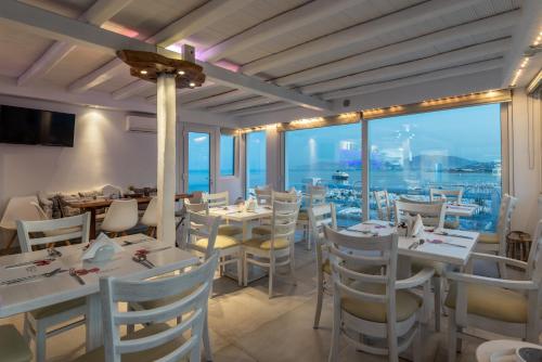 a restaurant with white tables and chairs with a view at Ibiscus Boutique in Mýkonos City