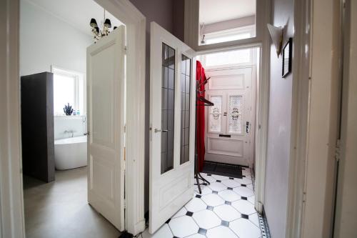 a hallway with a white door and a white tile floor at De Grift in Apeldoorn