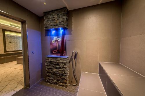 a bathroom with a stone wall and a shower with blue lights at Schloß-Hotel Petry in Treis-Karden