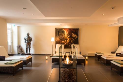 a living room with a statue of a man at Schloß-Hotel Petry in Treis-Karden