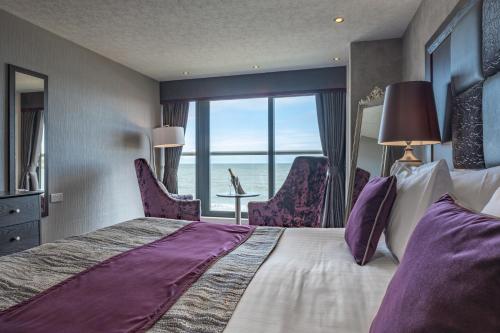 una camera d'albergo con un grande letto e vista sull'oceano di Number 44 Hotel & Bar a Stonehaven