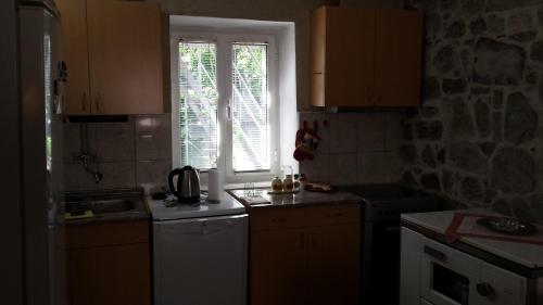 a kitchen with a sink and a window and a stove at Apartment Radovic in Kotor