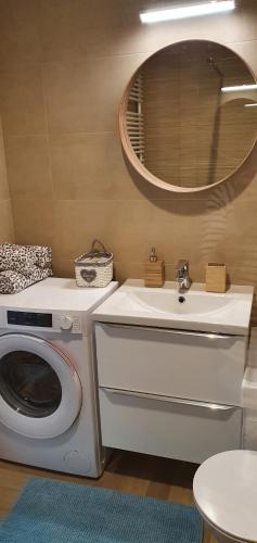 a bathroom with a washing machine and a sink at Apple Apartments - Mickiewicza PRYWATNE MIEJSCE PARKINGOWE in Łódź