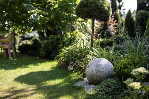 a garden with a stone ball in the grass at Apartamenty na Kasztelańskiej in Spytkowice