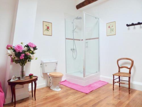 a bathroom with a shower and a table and a chair at Six chandelles m'étaient comptées in Puimoisson